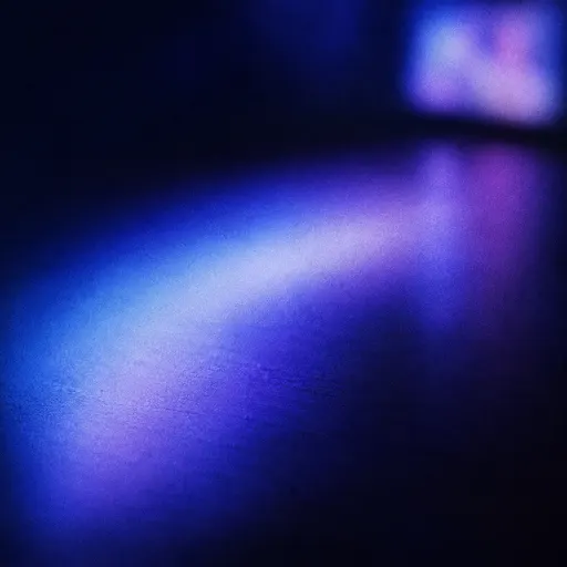 The glow of a screen falling across a dark desk